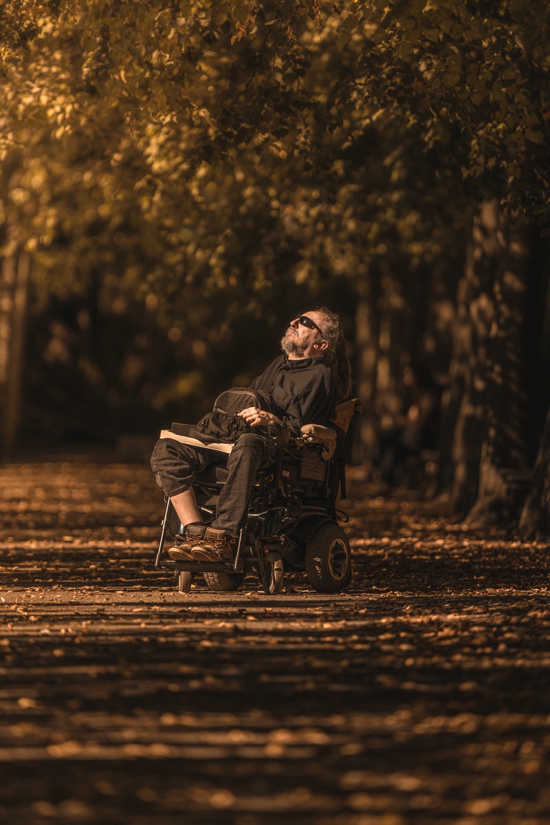 homme en fauteuil roulant électrique méditant dans la foret